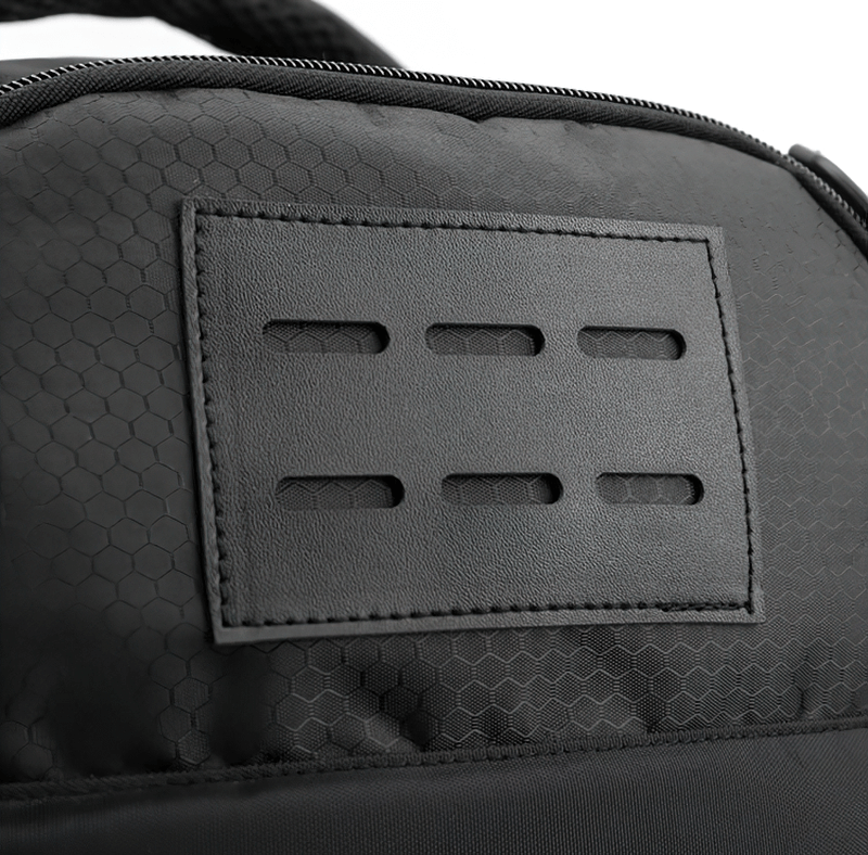 Close-up of black sports backpack with hexagonal pattern and leather detail, highlighting waterproof material and stylish design.